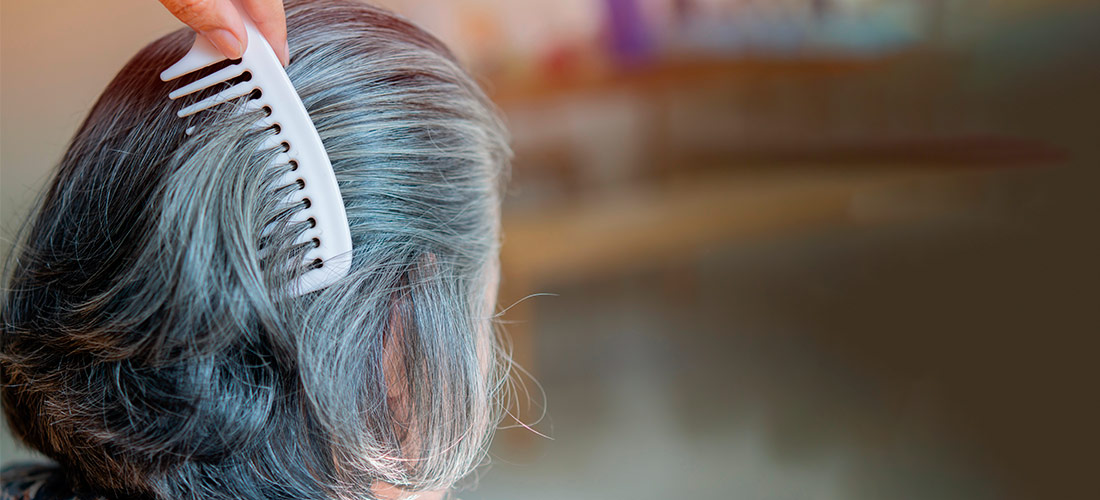 Mujer con canas a punto de echarse el tinte en un salón de belleza